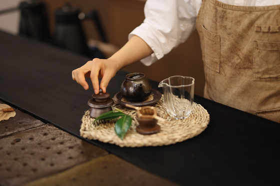 Traditional Jeju tea and drinkware being prepared on a woven mat